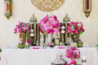 28 sweetheart table decorated with lanterns, candles and fuchsia colored florals