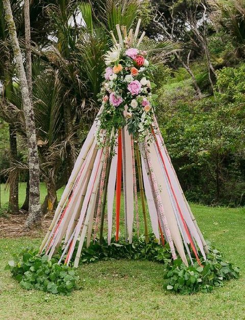 bold ribbon teepee with lush flowers on the top