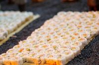 31 white rice covered sushi look spectacular on a surface covered with black beans