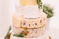 32 cheese tower displayed ona  wood slice with rosemary and small tomatoes