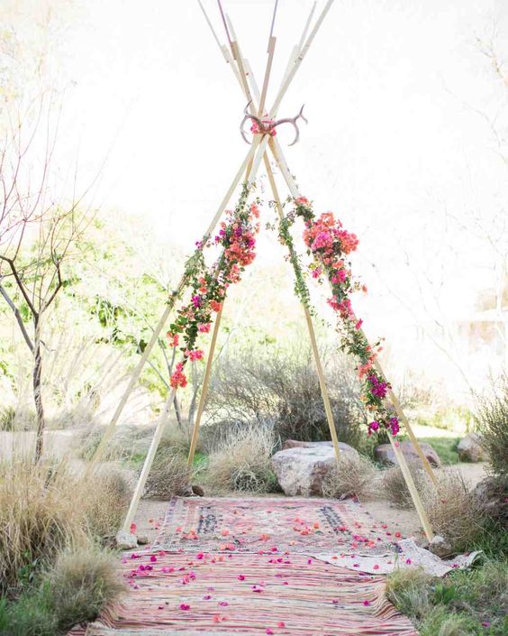 teepee-style wedding chuppah with antlers and bold flowers
