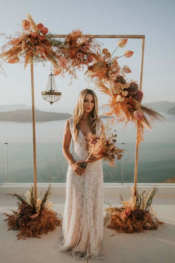 a bold boho wedding arch with colorful grasses and blooms plus some dried touches is amazing