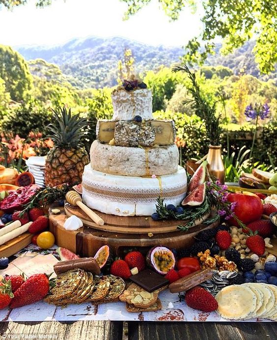 a cheese tower for a tropical wedding displayed with fresh fruit, berries and crackers