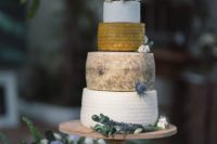 a cheese tower on a wooden stand and fresh blooms and thistles