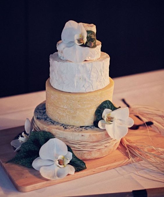 a cheese tower topped with white orchids for a tropical wedding