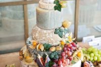 a chic and natural cheese tower with leaves, grapes and figs