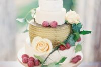 chic cheese wheel tower with grapes and peachy blooms on a wooden stand