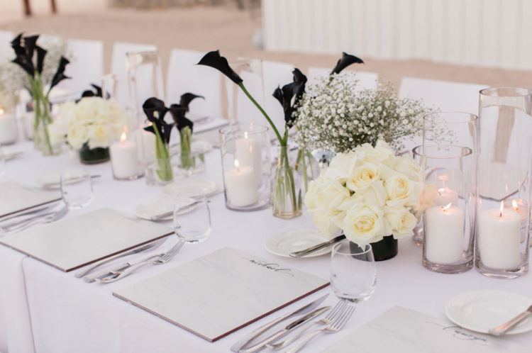 This is a tablescape for the rehearsal dinner, baby's breath and white roses contrast with black callas