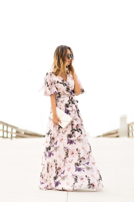 a delicate floral maxi dress with short sleeves and a white clutch
