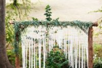 04 a rustic log arch with crochet lace and greenery for a camp ceremony