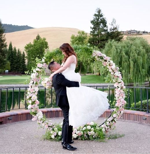 a blush flower and greenery wreath and a lake behind for a gorgeous backdrop