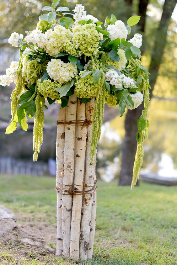 birch branches secured with twine and hydrangeas on top for the aisle decor