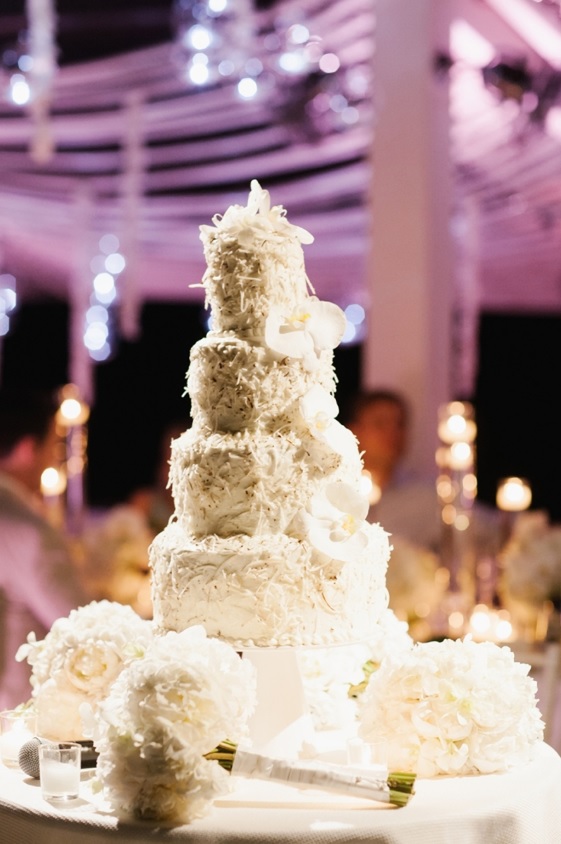 The wedding cake was textural and white with coconut and displayed with white florals