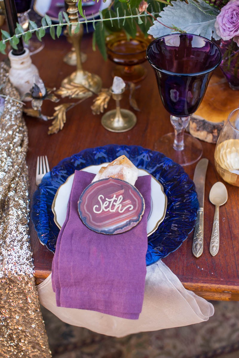 The wedding table setting was deccorated with bold blue plates, purple glasses and of course stone slices