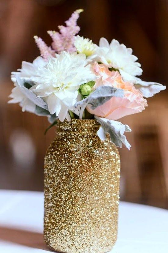 a glittered mason jar with blush and white flowers