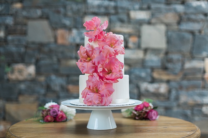 The wedding cake was decorated with large pink blooms to keep the theme of the shoot