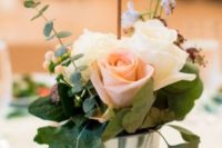 09 a bucket with blush and white roses, leaves and eucalyptus, a wood slice table number