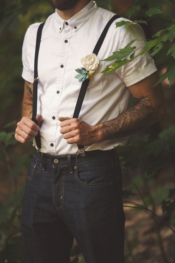 black jeans, an ivory short sleeve shirt with black buttons and black suspenders