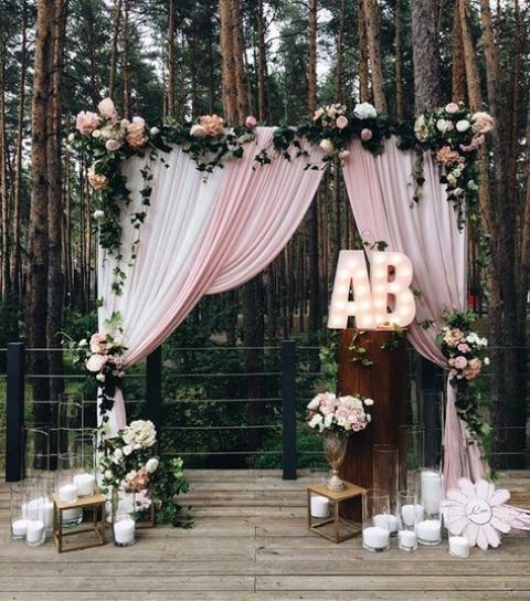cute altar with pink curtains, pink and blush flowers, candles and marquee letters