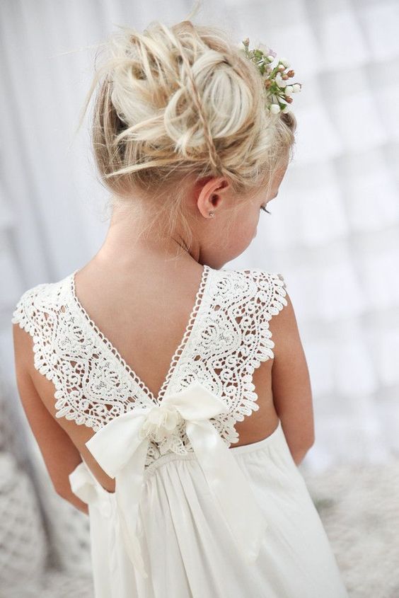 flower girl with an amazing hairstyle in an off-white maxi dress with a V back of crochet lace