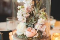 12 a jar on a wooden stand and moss, succulents and fresh blooms inside