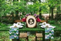 12 a small moss covered table with bold flowers and a wood slice sign