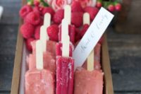 12 berry popsicles in a box and fresh raspberries