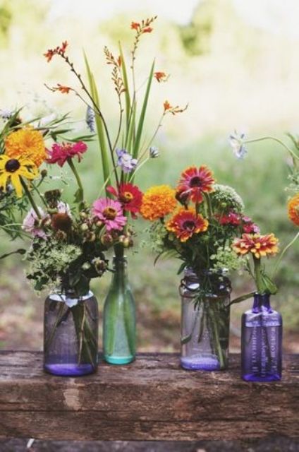 colored glass bottle vases with wildflowers will be a nice and centerpiece