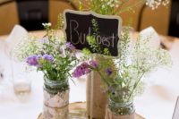 14 a wood slice with mason jars covered with burlap and with fresh flowers inside