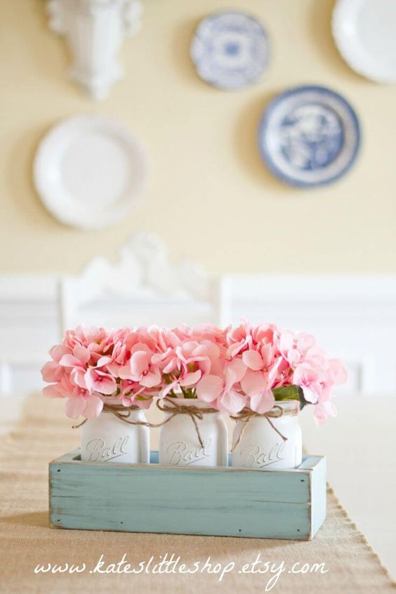 a mint-colored crate with whitewashed mason jar and pink flowers