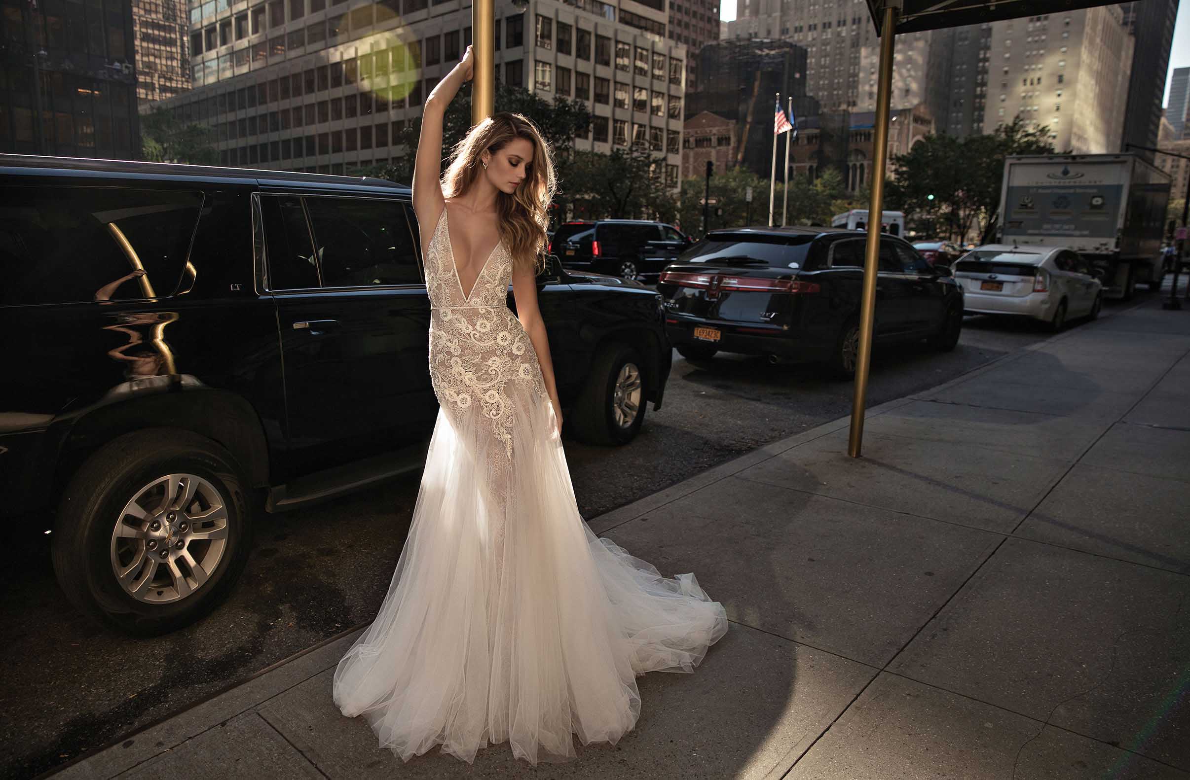 A plunging neckline wedding dress with lace appliques and a light mermaid silhouette, a tulle skirt