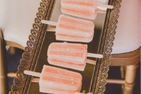 18 pink grapefruit popsicles served on a mirrored tray