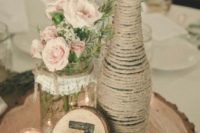 20 a wood slice with a twine wrapped bottle and a mason jar, flowers and a wood burnt table number