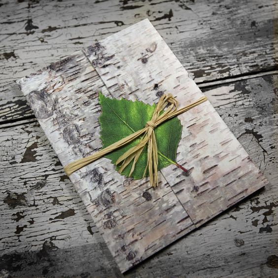 birch bark invitation topped with a green leaf