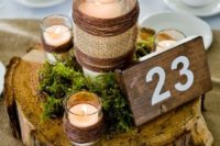 21 a wood slice with candle holders wrapped with burlap and yarn, a wooden table number