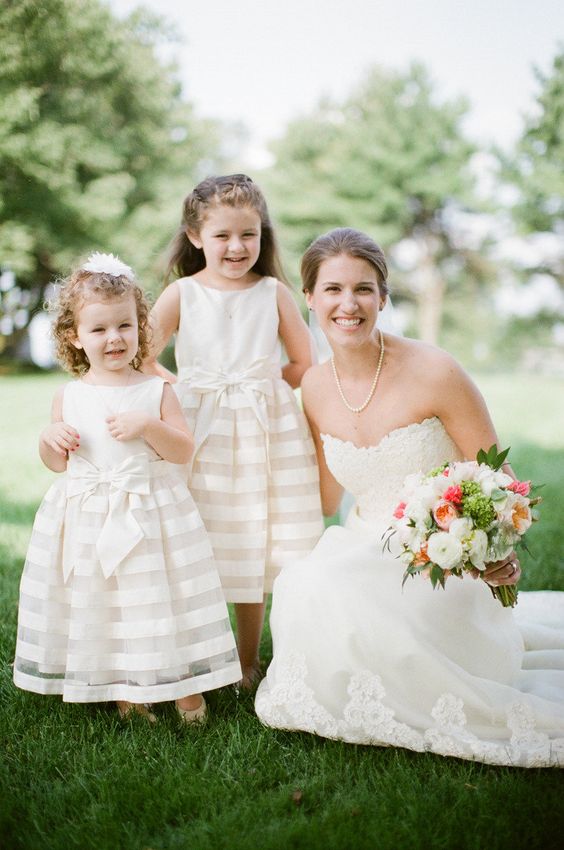sleeveless ivory dresses with striped skirts and bows on the waist