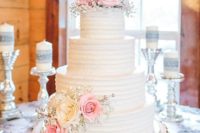 21 white multi-tiered cake topped with pink roses and baby’s breath