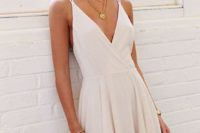 23 an ivory skater dress with a pleated skirt, a deep V neckline and straps