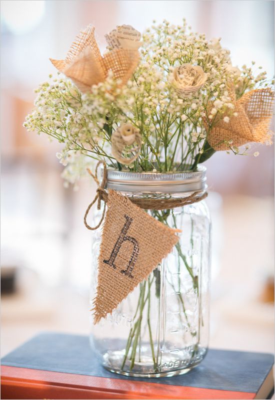 mason jar with a burlap table marking and baby's breath plus burlap flowers