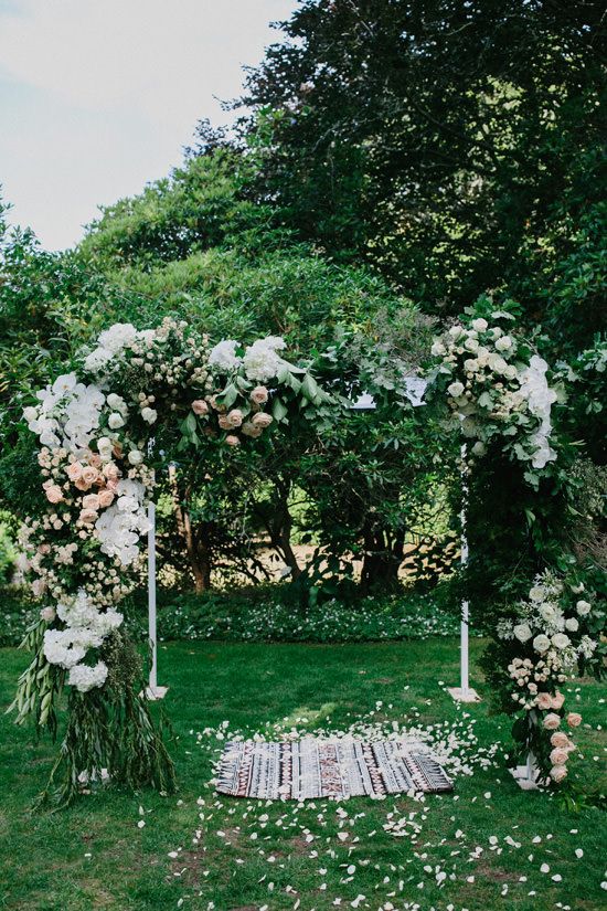 super lush wedding arch with lots of greenery, blush and white blooms