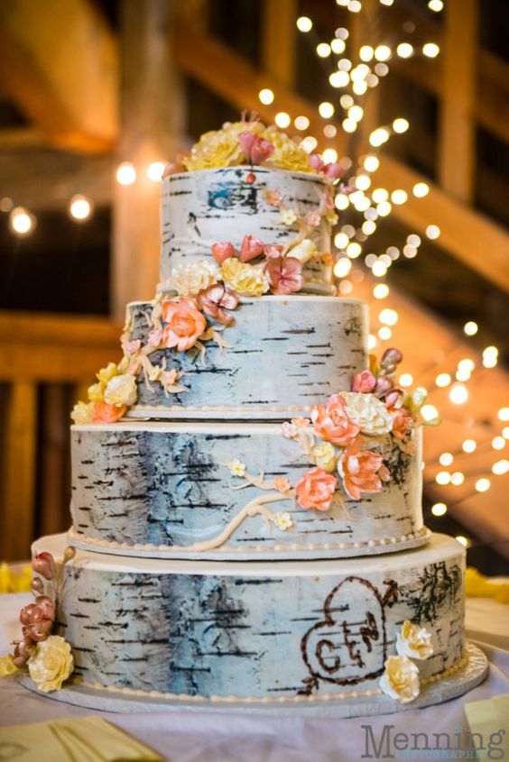 a multi-tiered birch cake topped with edible flowers