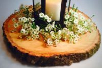 30 a wood slice covered with wildflowers and a black candle lantern