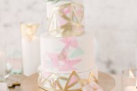 31 a modern geometrical wedding cake topped with an air plant