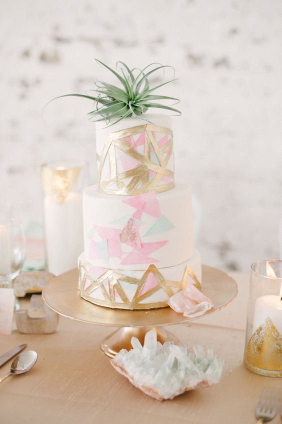 a modern geometrical wedding cake topped with an air plant