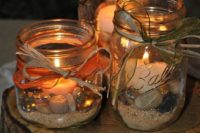 38 three mason jars with sand and pebbles plus candles inside for a coastal wedding
