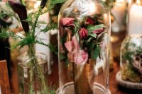 a lovely cloche wedding centerpiece of a pink flower arrangement in a vase placed in a cloche