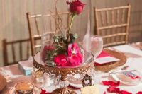 a refined fairy tale wedding centerpiece of a vintage cloche, bright petals, a rose, crystals and a vintage frame