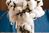 a rustic wedding centerpiece of a jar with cotton and bunny tails is a super soft and cozy idea for a rustic fall or winter wedding