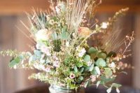 a summer wedding centerpiece of freshly picked wildflowers and greenery in a jar with twine can be easily DIYed