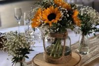a triple rustic wedding centerpiece of vases with baby’s breath and sunflowers is a gorgeous idea for a bright summer wedding in rustic style